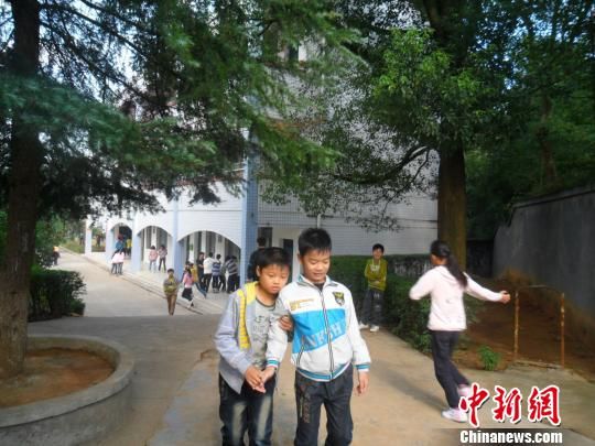 4年來，13歲的余興泉（左一）每天都攙扶著腿腳不便的同學(xué)左臣進(jìn)出教室、食堂和廁所。 李俊杰 攝