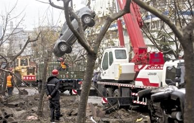 輸油管道爆炸后，搶修人員將被炸毀的車輛運出現(xiàn)場。