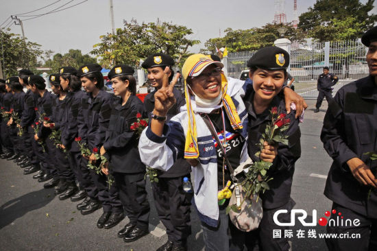 2013年12月03日,曼谷總理府與曼谷警署允許反政府示威民眾進(jìn)入,雙方進(jìn)入暫時(shí)“停戰(zhàn)”狀態(tài)迎接泰王生日。曼谷警察總署,女警們手持鮮花送給反政府示威民眾。圖片來源:Manish Swarup/東方IC