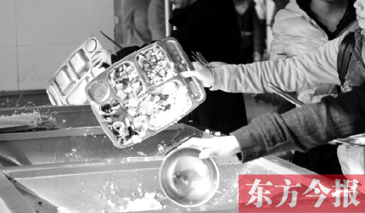 11月27日，河南中醫(yī)學(xué)院餐廳，一名同學(xué)將餐盤內(nèi)沒吃完的食物倒入餐具回收車內(nèi)