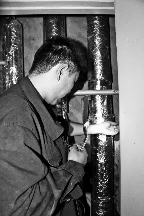 苗師傅一邊進(jìn)行維修，一邊用耳機(jī)接聽市民的電話。