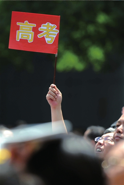 6月7日，在東直門(mén)考點(diǎn)外，一名家長(zhǎng)手舉高考的小旗子迎接孩子。資料圖片本報(bào)記者王苡萱攝