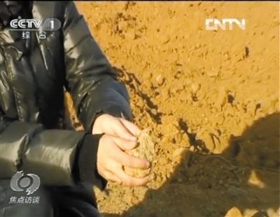 麻剛沙系麻剛石粉碎而成。記者找到一塊麻剛石，一捏就碎成粉末，硬度非常差。央視截圖