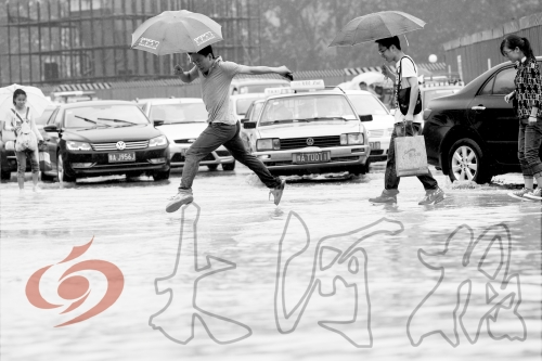 鄭州經(jīng)三路與北環(huán)交叉口處，積水較深，行人們不得不“練輕功”。 記者 白周峰 攝影