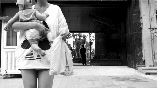 抱著孩子出售人奶的女子。