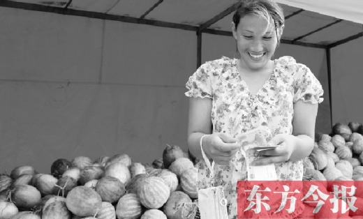 昨日，開(kāi)封瓜農(nóng)史瑩瑩幸福地?cái)?shù)著賣瓜錢(qián)