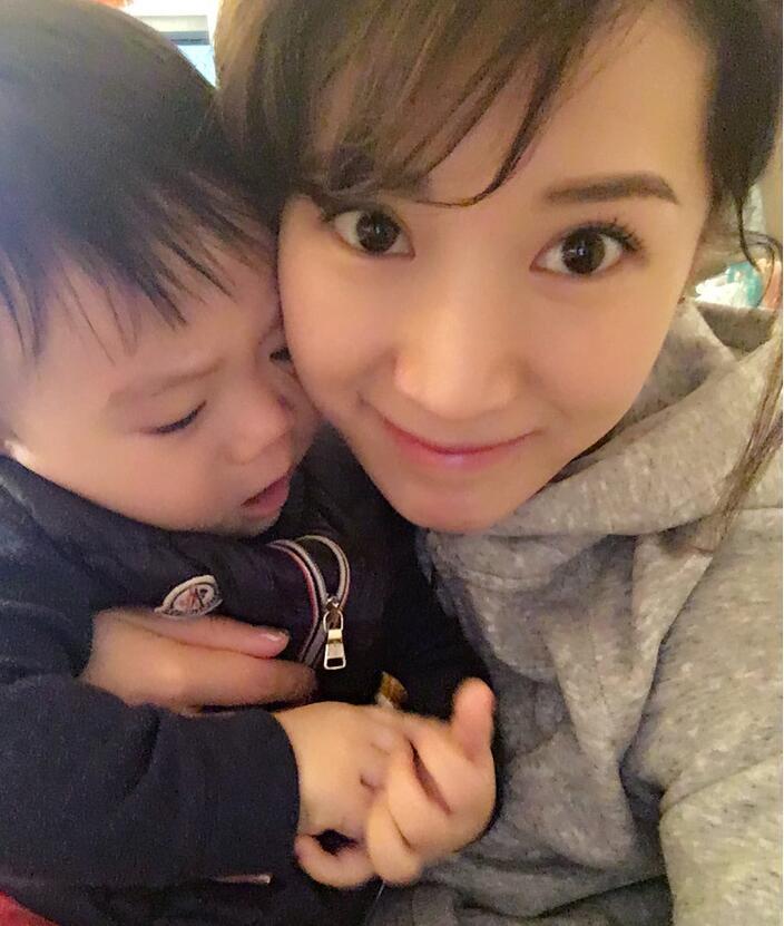 照片中李念狂吻兒子，小寶貝自顧自地玩著。