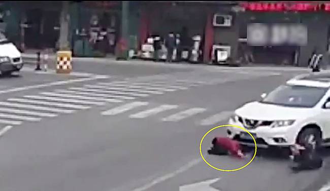 圖為小姑娘被卷進(jìn)車輪下瞬間。
