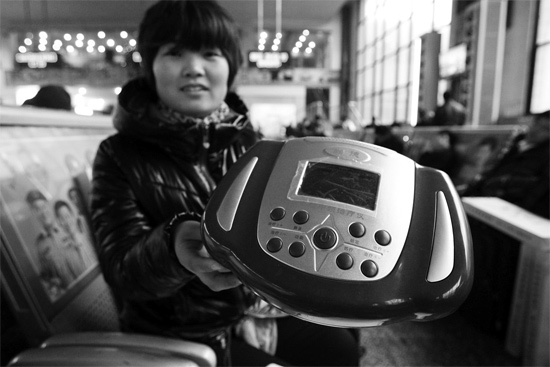 火車站候車室，李女士向記者展示她準(zhǔn)備孝敬父母的按摩儀