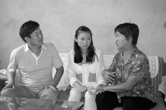 “商丘最美女兒”李丹（中）捐骨髓救母，愛(ài)心人士（左）送來(lái)1萬(wàn)元愛(ài)心款