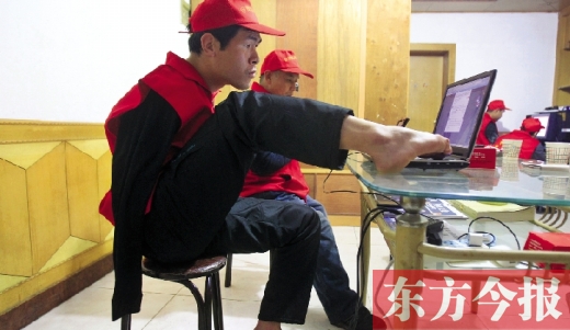 12月2日，一名“豫殘聯(lián)盟”志愿者正通過網(wǎng)絡(luò)、微博等聯(lián)絡(luò)著各地殘疾人朋友 東方今報首席記者 張曉冬