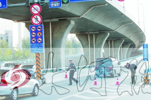 交警在東風(fēng)路從北向南上橋口處擺上反光錐，間歇放行