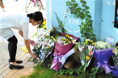6月8日下午，記者來到廈門公交車爆炸事發(fā)現(xiàn)場橋下，附近已聚集了十幾個(gè)自發(fā)前來悼念的市民。橋墩下排放了一圈或黃或白的菊花，還有玖瑰、百合等。