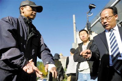 常林鋒在法院外展示雙手，他稱被燙傷的手因刑訊逼供且未得到及時救治