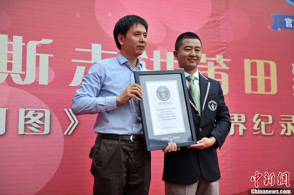 圖為世界吉尼斯認證官為鄭春輝（左）頒發(fā)證書。呂明 攝