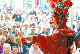 圖為8月15日戲曲演員在“流動舞臺車”上表演傳統(tǒng)地方戲《穆桂英下山》。
