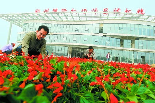 9月23日，工人們正在鄭州國際機場許昌候機樓前擺放鮮花。