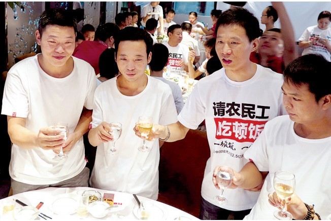 活動(dòng)發(fā)起人張楠（右二）給農(nóng)民工敬酒。
