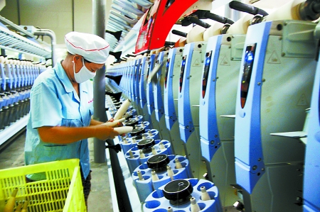 7月3日，在鄧州市永泰棉紡有限公司電腦控制全自動(dòng)紡紗車間，紡織工人正在生產(chǎn)棉紗。