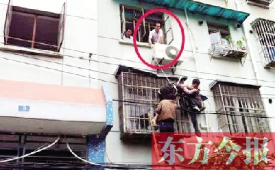 施救現(xiàn)場，劉鵬（圈內(nèi)）先用繩子捆住老太確保安全 勞動報記者 郭娜 供圖