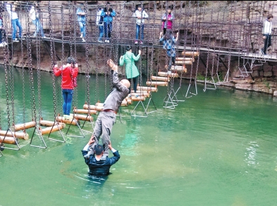 中年男游客正踩著景區(qū)安全員郭小明的肩膀過(guò)河。網(wǎng)友“@我的小名叫張孩”供圖