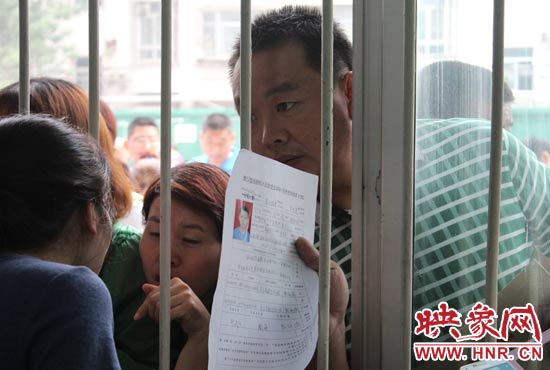 不少家長(zhǎng)擠在報(bào)名窗口前咨詢報(bào)名事宜。