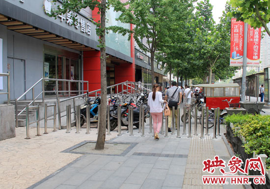 圖中道路左側(cè)的無(wú)障礙通道被鋼管隔離,右側(cè)的盲道也被侵占。