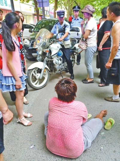 在鄭州優(yōu)勝南路東三街交叉口向東100米處，一名短發(fā)中年女子平躺在路南快車道上，身旁還有一只掉落的拖鞋