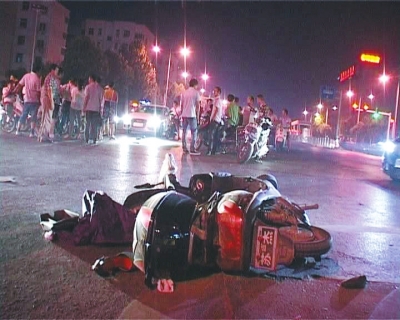 一輛白色無牌奧迪轎車在通過路口時(shí)，將一名騎電動(dòng)車的女子撞飛十多米