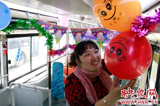 鄭州快速公交B3區(qū)間線車長李鵬云在車廂里懸掛氣球，布置圣誕車廂，營造歡樂圣誕氛圍