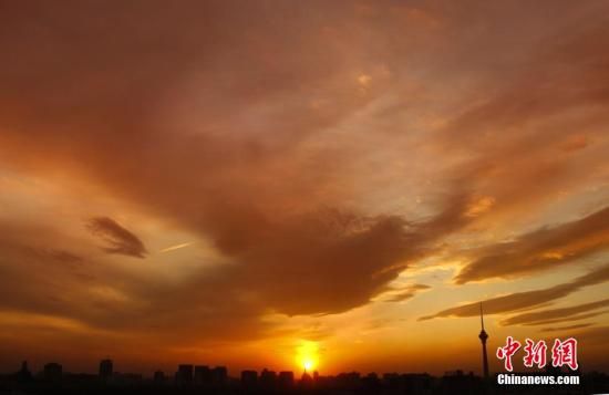 12月8日下午，強(qiáng)烈的西北風(fēng)光臨北京，吹散了籠罩全城上空的霧霾，冬日罕見的艷麗晚霞映紅了半邊天。
