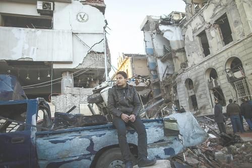 埃及曼蘇拉市警察局24日遭汽車(chē)炸彈襲擊，被疑是穆兄會(huì)的報(bào)復(fù)。圖為一名男子在被炸毀的警察局前。