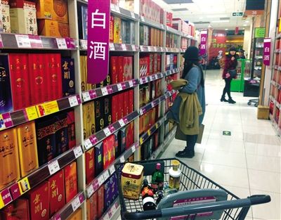 顧客在商場(chǎng)的高檔白酒貨架前駐足挑選。春節(jié)臨近，受“禁令”影響，以高檔白酒為代表的節(jié)日禮品市場(chǎng)面臨考驗(yàn)。記者 王遠(yuǎn)征 攝