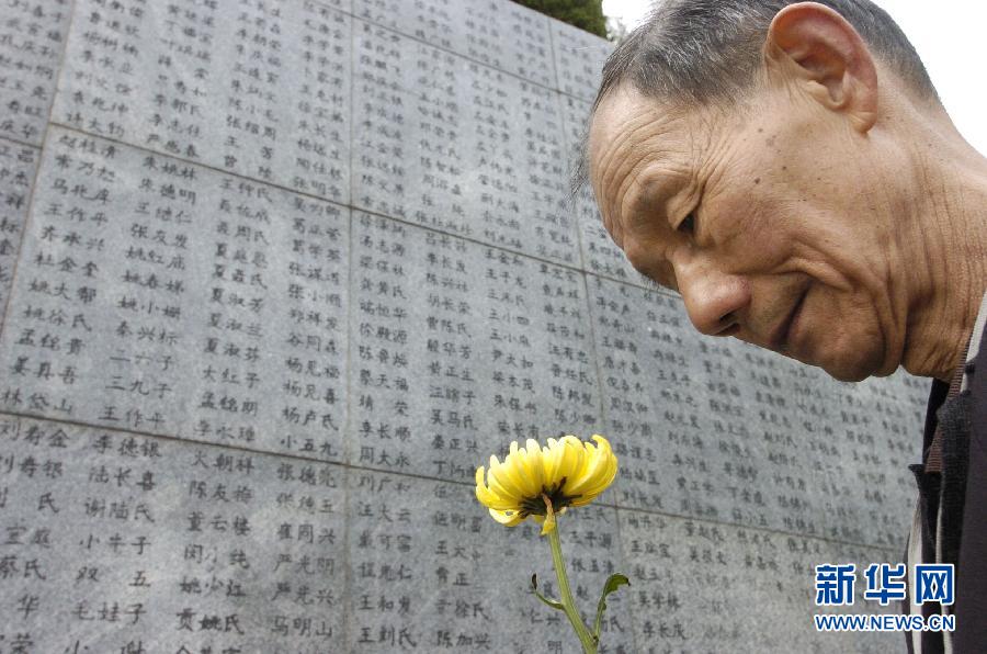 2006年4月5日，74歲的南京大屠殺幸存者佘子清手捧鮮花，祭奠被日軍殺害的母親。