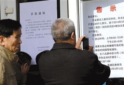 昨日，家長(zhǎng)在西安市楓韻幼兒園查看有關(guān)兒童體檢的告示。