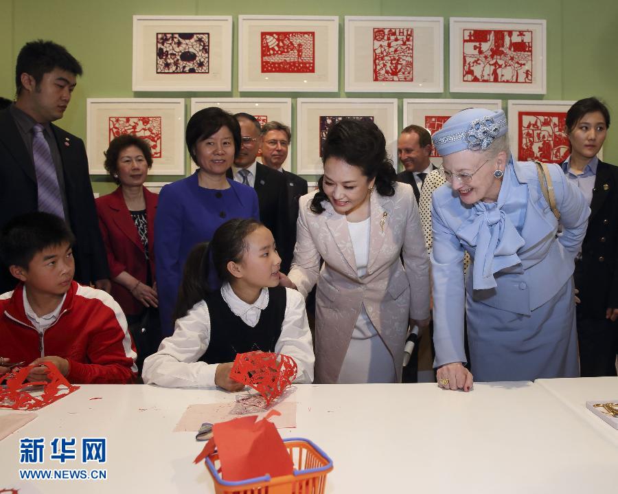 這是彭麗媛和瑪格麗特二世與根據(jù)安徒生童話中人物和情節(jié)制作剪紙的孩子交談。