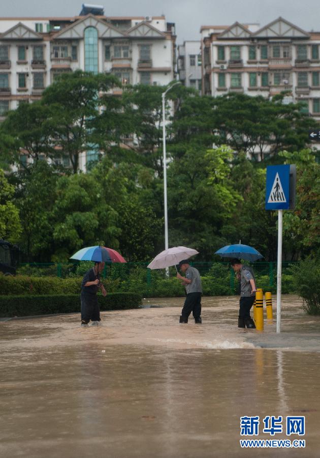 5月11日，人們在深圳西麗涉水行走。