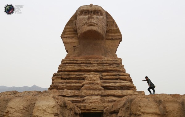石家莊郊外，一名男子與山寨版獅身人面像合影留念。