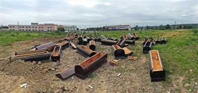40多副棺木被砸壞后，扔在荒地上。