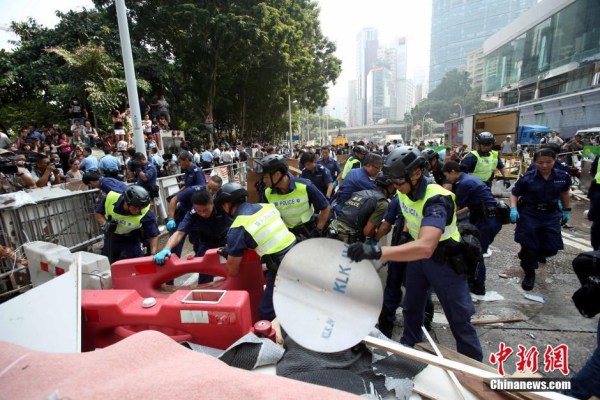 10月14日，警方清除金鐘道障礙物。大批警員在金鐘道現(xiàn)場(chǎng)清拆障礙物。部分警員戴上頭盔將障礙物移走。