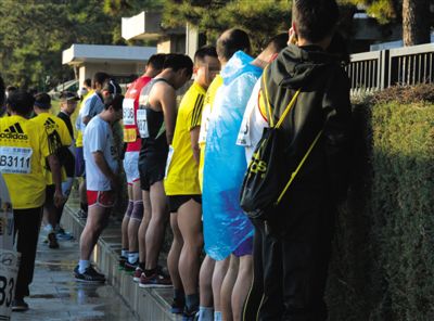 2013年10月20日，北京馬拉松比賽，由于廁位有限，一些選手在綠化帶“就地解決”。圖/IC