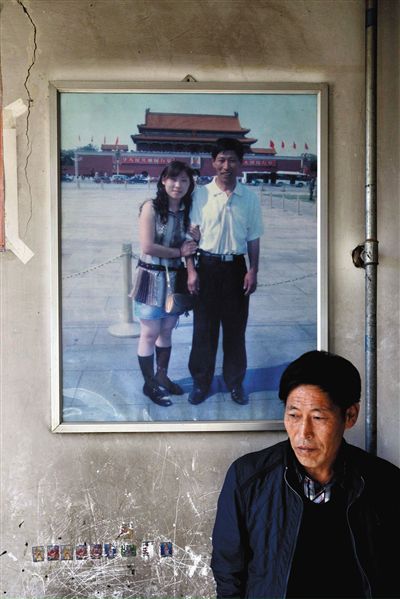 11月14日，承德市平泉縣，潘小梅父母的家，潘小梅父親靠在墻上，身后掛著數(shù)年前他和潘小梅在北京的合影照片。新京報記者