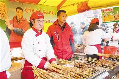賣羊肉串攤位老板趙山（穿紅衣者）。新京報記者