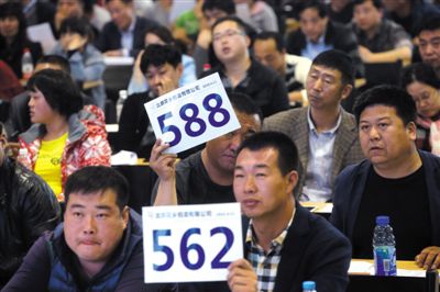 昨日，拍賣現(xiàn)場競拍者舉牌競拍。新京報記者