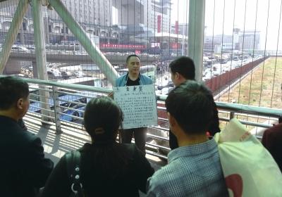 韓先生在北京西站天橋上籌錢(qián)。京華時(shí)報(bào)記者陶冉攝