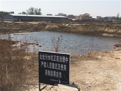 化肥廠滲坑的三分之一經(jīng)過治理，但水質(zhì)仍然呈黃褐色。