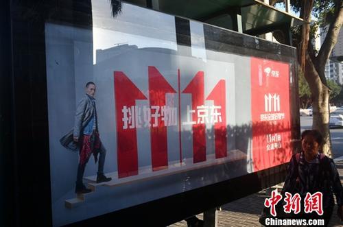 資料圖：11月1日，福州民眾從雙十一廣告牌前經(jīng)過(guò)。中新社記者 呂明 攝