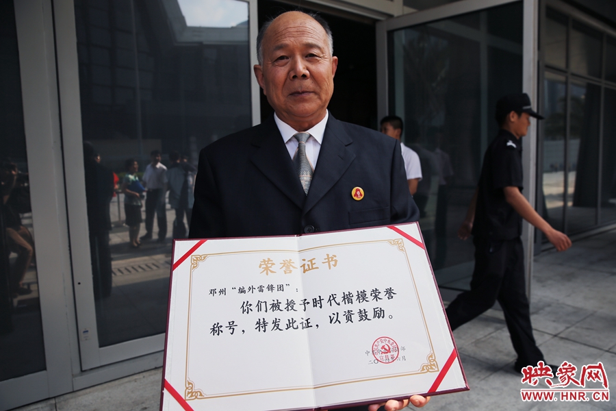 河南鄧州“編外雷鋒團(tuán)”團(tuán)長宋清梅向眾多記者展示中宣部授予的“時代楷模”榮譽(yù)證書。