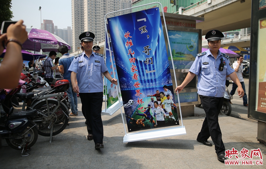 7月2日上午，鄭州市紫荊山地鐵站出入口，執(zhí)法人員抬著寫有勸導(dǎo)語(yǔ)的宣傳板，前往占道經(jīng)營(yíng)攤位“圍觀執(zhí)法”