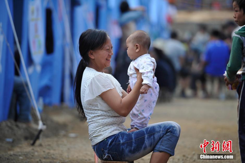 8月6日，一名年輕的母親在和孩子玩樂。